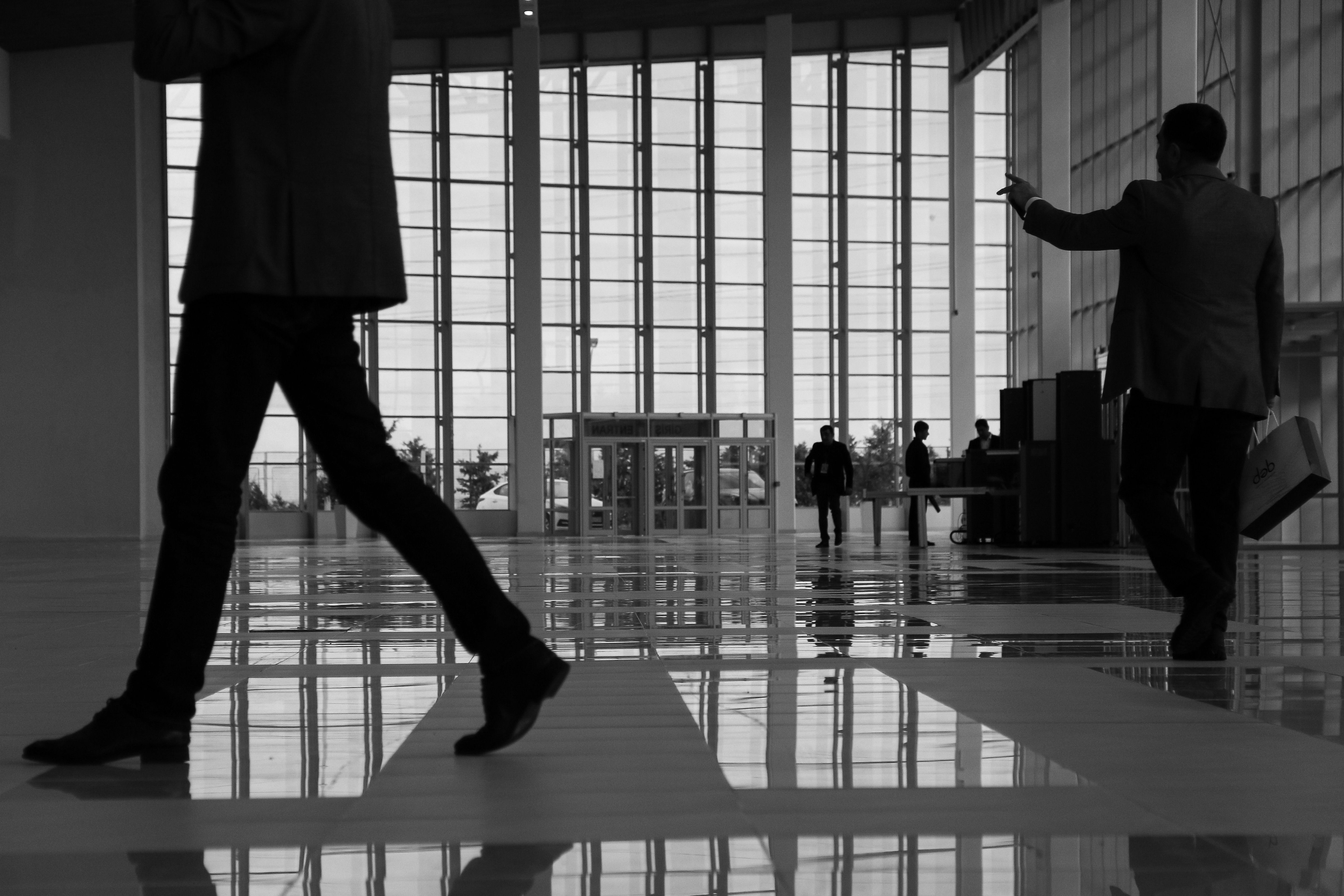 People moving through a modern glass-lined interior.